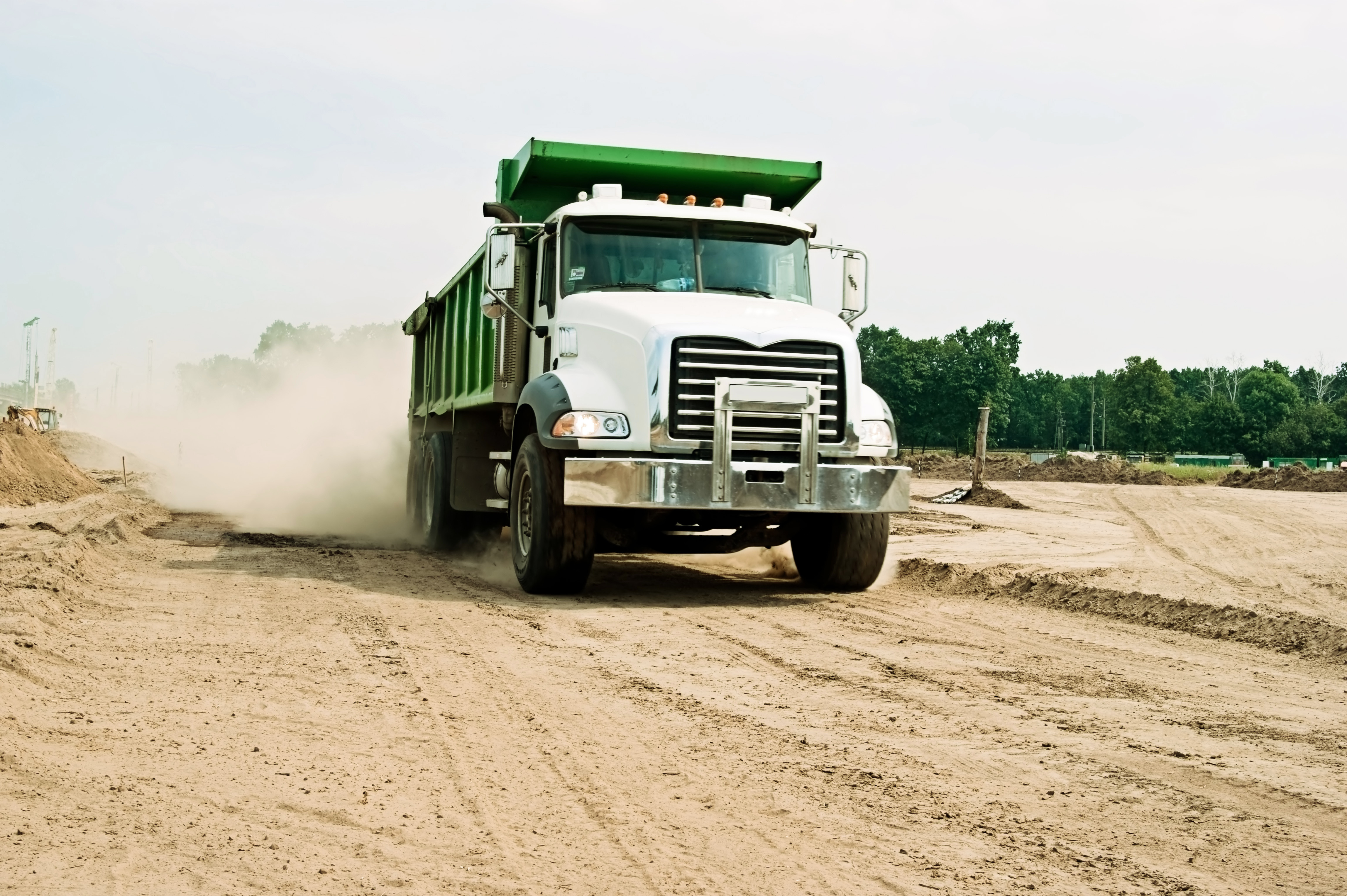 solitary dump truck driving on dirt job site