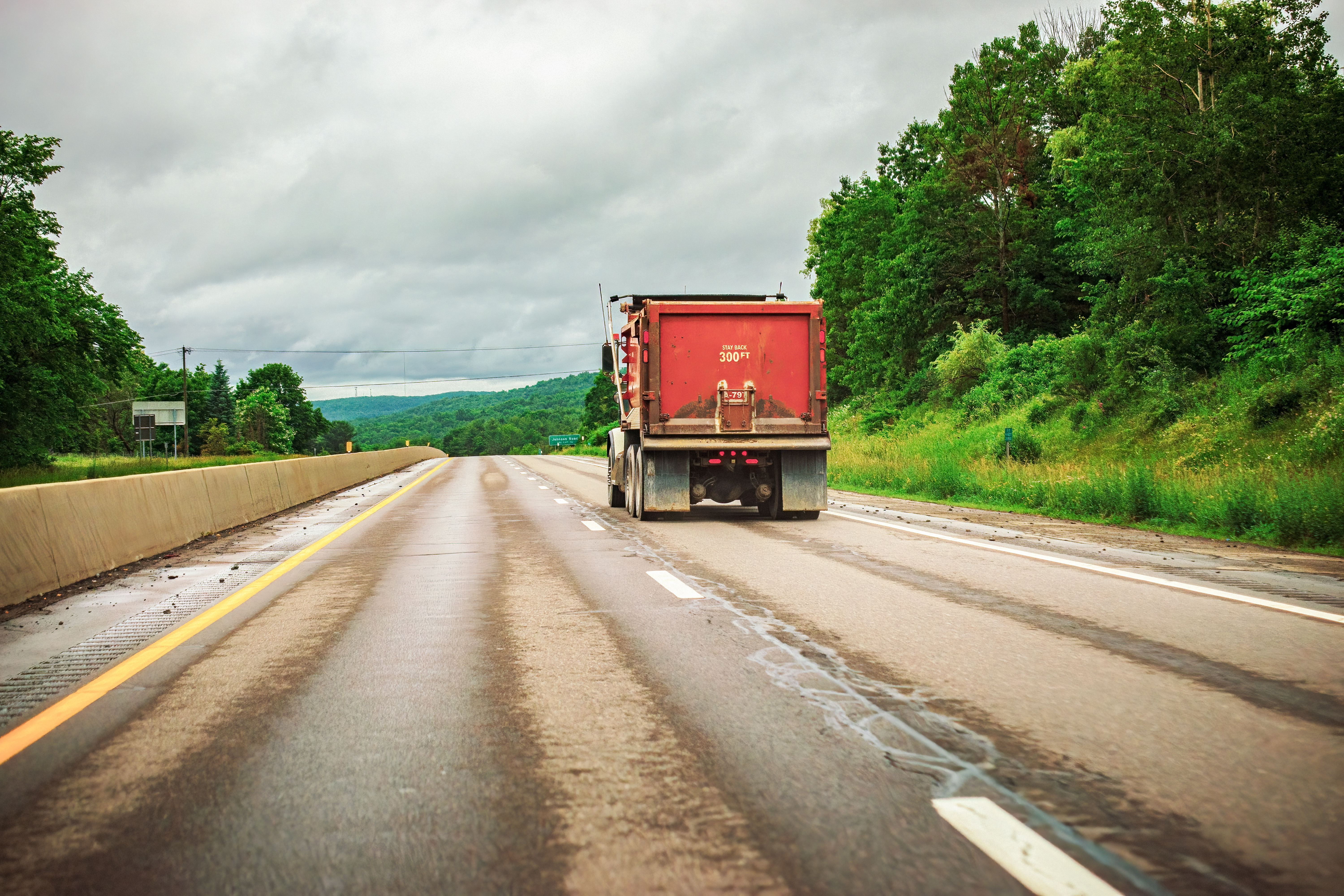 solitary dump truck driving on highway