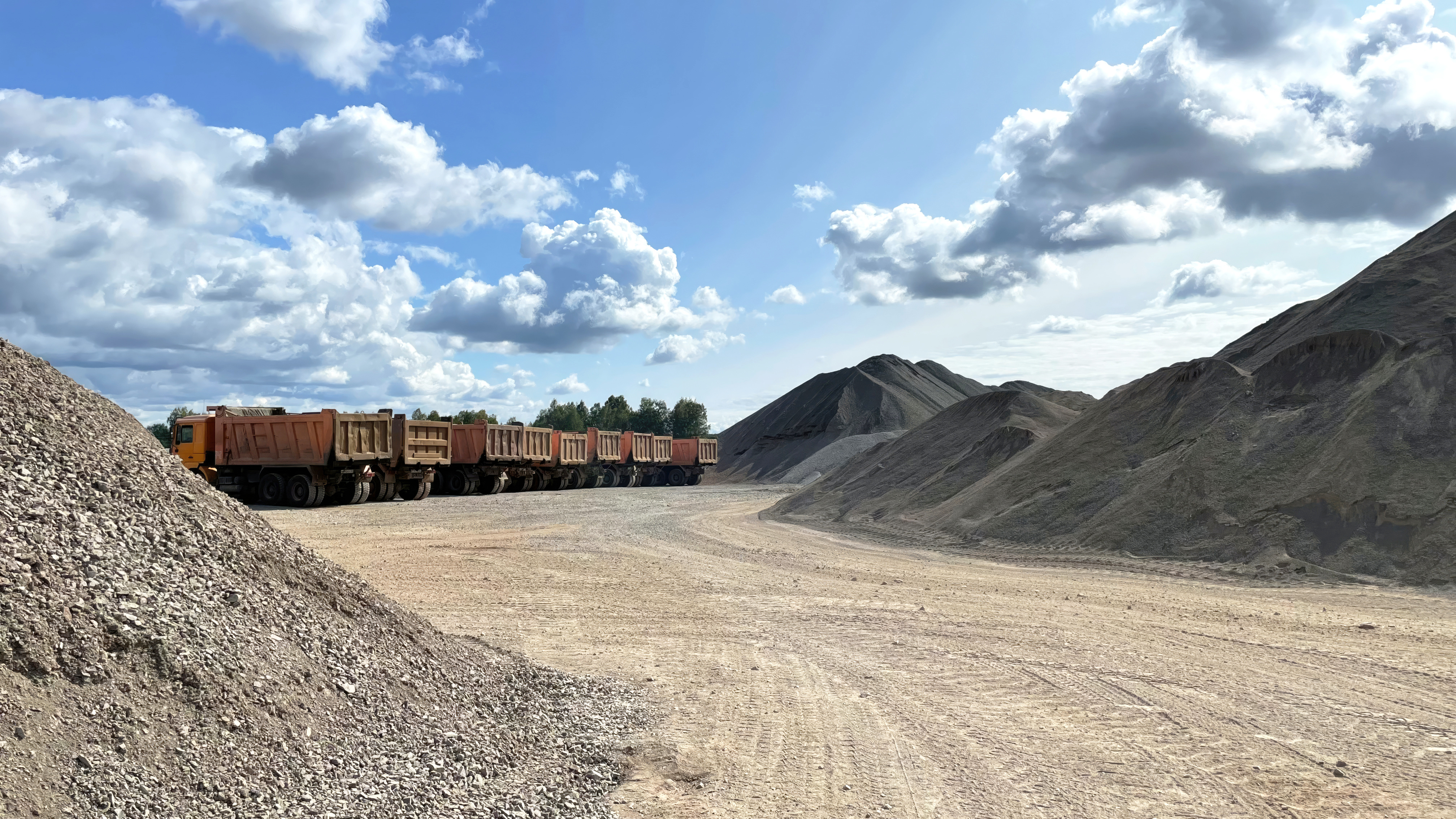 dump truck fleet parked at quarry